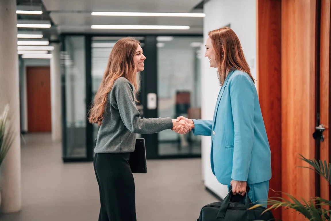 Zwei Frauen schütteln Hände im Büro